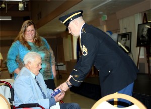 Dee J. Valentine, a Hospice Care of the West patient, receives the flag from the Military Color Guard at his 100th birthday life celebration. Courtesy of Michelle Miller